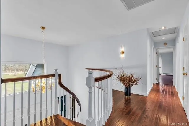 a view of hallway with stairs and wooden floor
