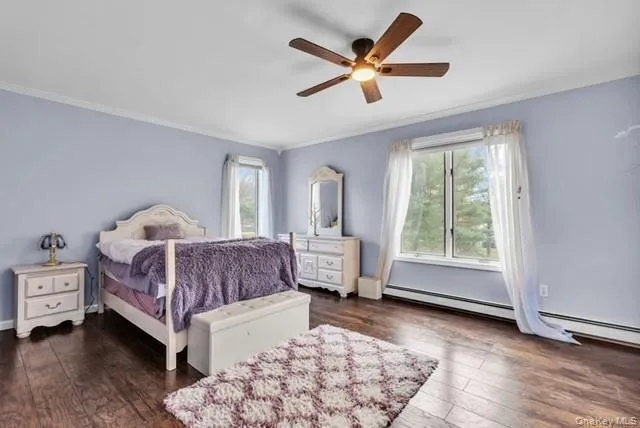 a bedroom with a bed a chair and a large window