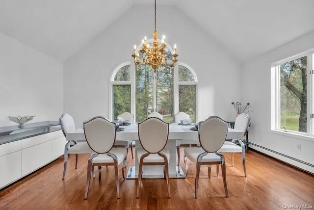 a view of a dining room with furniture a chandelier and wooden floor