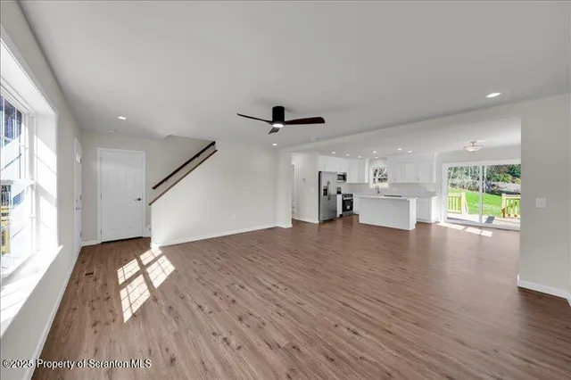 a view of empty room with wooden floor and windows