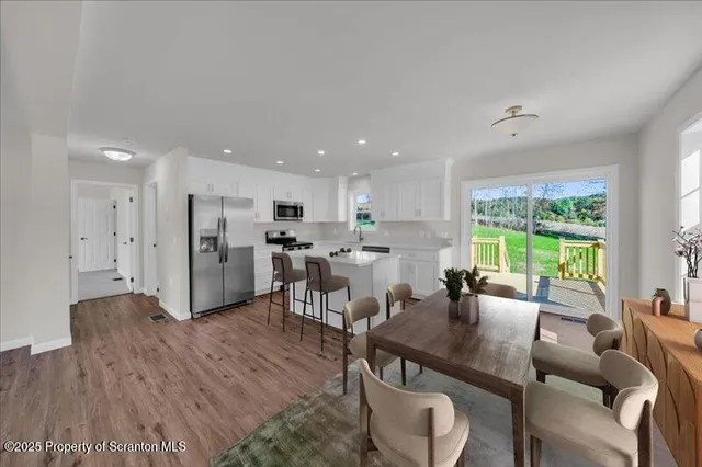 a living room with furniture a large window and stainless steel appliances
