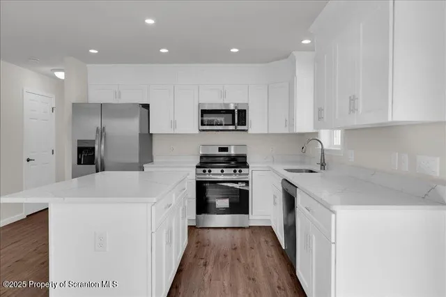 a kitchen with granite countertop a sink stove and refrigerator