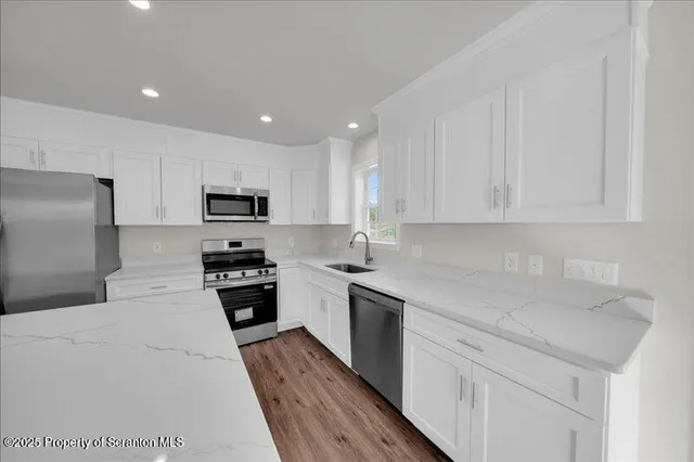 a kitchen with cabinets appliances a sink and a counter top space