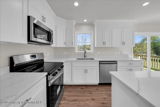 a kitchen with cabinets appliances a sink and a window