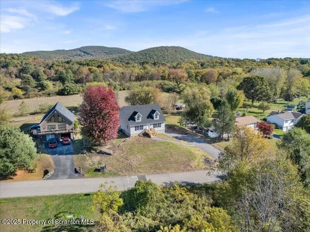 an aerial view of a house with a mountain