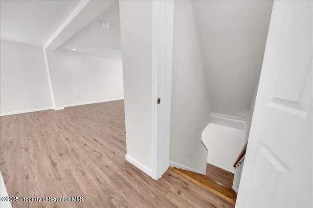 a view of a hallway with wooden floor and chair