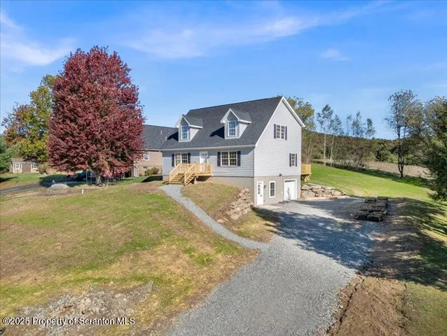 a front view of house with yard and trees in the background
