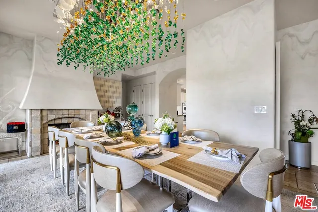 a kitchen with granite countertop a stove a sink a dining table and chairs