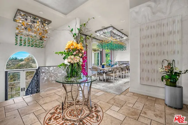 a living room with patio furniture and a chandelier