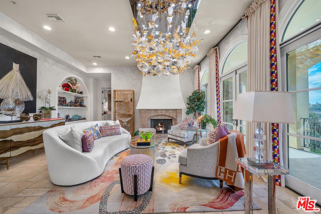 3110 Benedict Canyon Drive Beverly Hills, CA 90210 - Photo 7 of 70 a living room with fireplace furniture and a chandelier