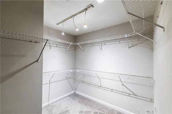 an empty room with windows and ceiling fan