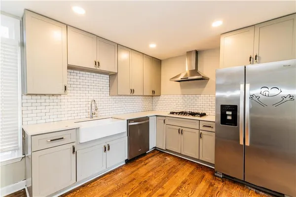 a view of a kitchen with refrigerator and wooden floor