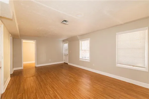 a view of a small space with wooden floor and a window