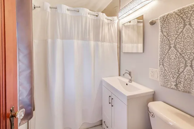 a bathroom with a sink a toilet and shower curtain