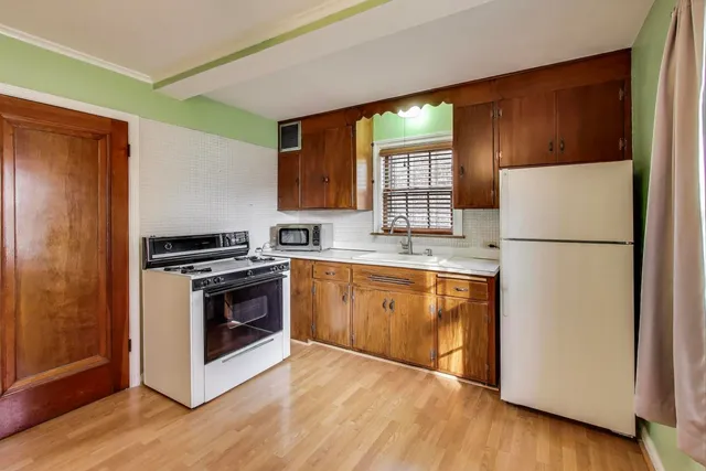 a kitchen with granite countertop a refrigerator stove and sink