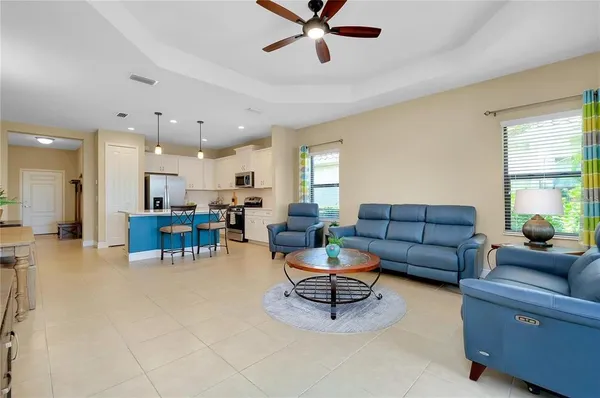 a living room with furniture kitchen view and a window