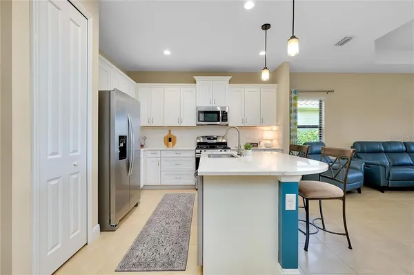 a kitchen with stainless steel appliances granite countertop a refrigerator a sink dishwasher a stove and a refrigerator with wooden floor