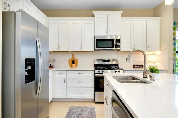 a kitchen with stainless steel appliances granite countertop a refrigerator sink and stove