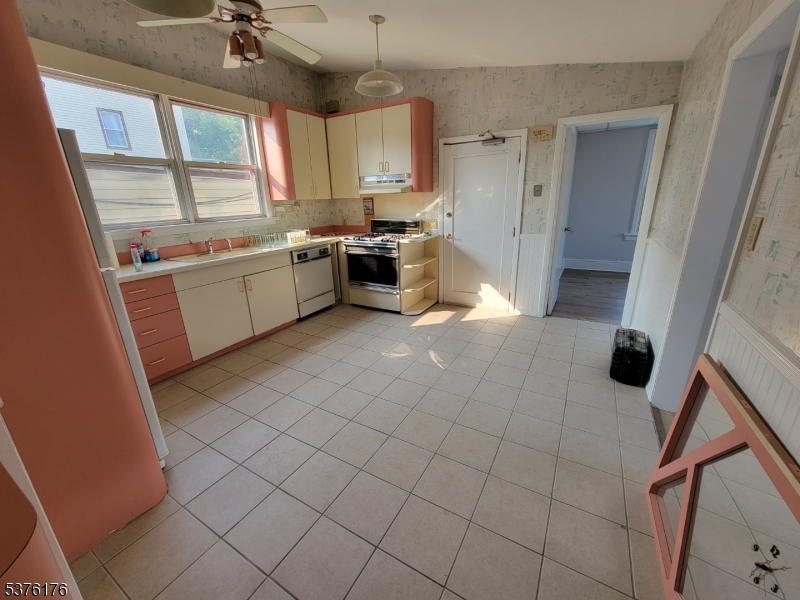 a kitchen with a sink a stove cabinets and a window