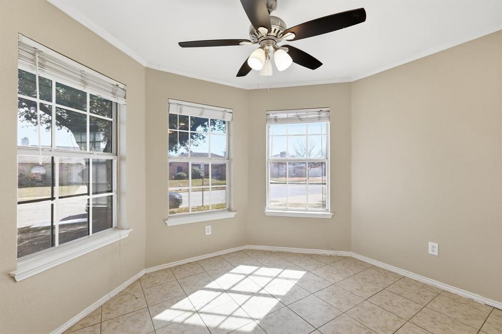 7733 Liz Lane Watauga, TX 76148 - Photo 12 of 27 Unfurnished room with ceiling fan, ornamental molding, and light tile patterned flooring