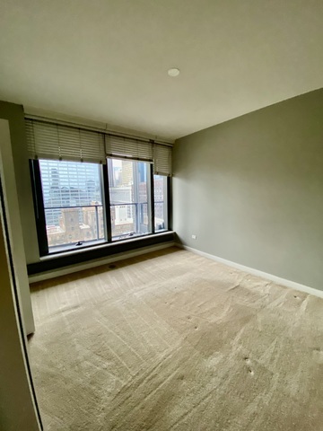60 East Monroe Street, Unit 2205 Chicago, IL 60603 - Photo 7 of 22 an empty room with wooden floor and windows