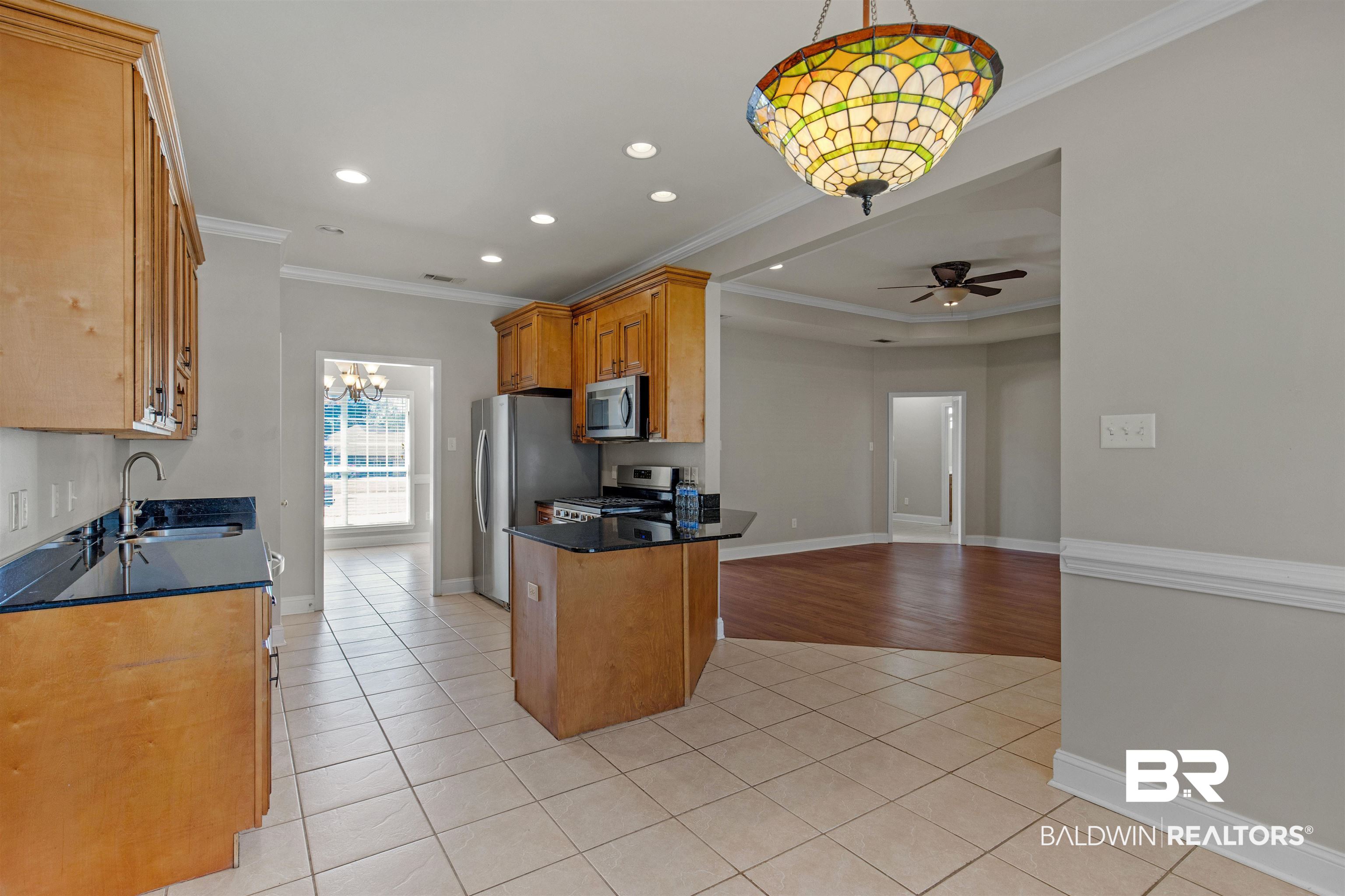 330 Allison Court Mobile, AL 36608 - Photo 8 of 27 Kitchen featuring sink, hanging light fixtures, light tile patterned floors, appliances with stainless steel finishes, and ceiling fan with notable chandelier