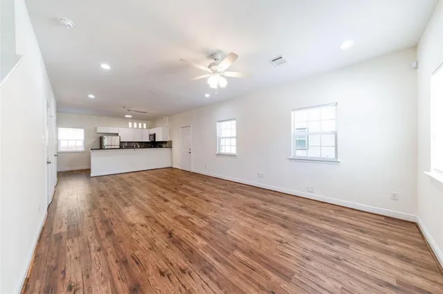a view of empty room with kitchen and window