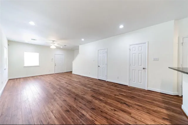 a view of a room with wooden floors and white walls