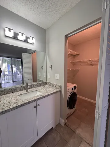 a bathroom with a granite countertop sink a mirror and vanity