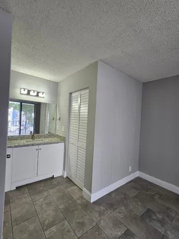 a bathroom with granite countertop a sink and a mirror
