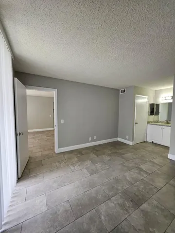 a view of an empty room and kitchen