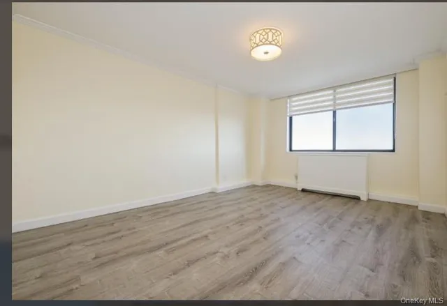 an empty room with wooden floor and a window