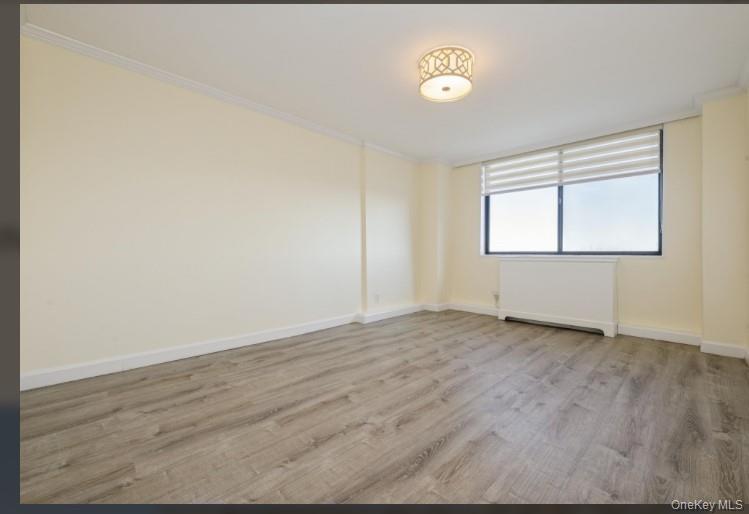 2 Bay Club Drive, Unit 17Z2 Queens, NY 11360 - Photo 11 of 17 an empty room with wooden floor and a window