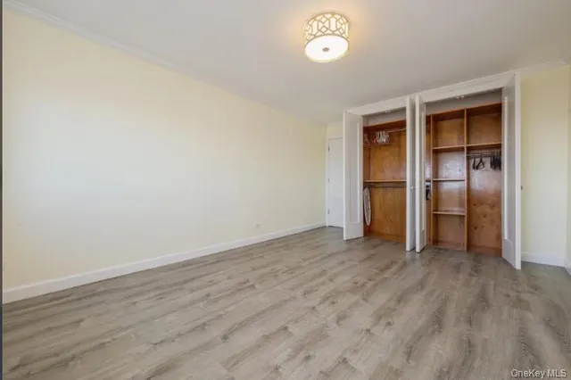 an empty room with wooden floor and closet