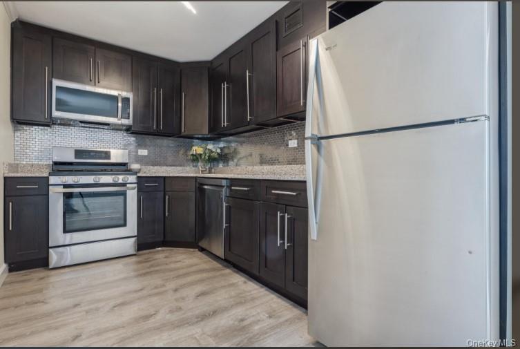 2 Bay Club Drive, Unit 17Z2 Queens, NY 11360 - Photo 2 of 17 a kitchen with stainless steel appliances granite countertop a refrigerator a stove a sink and a microwave