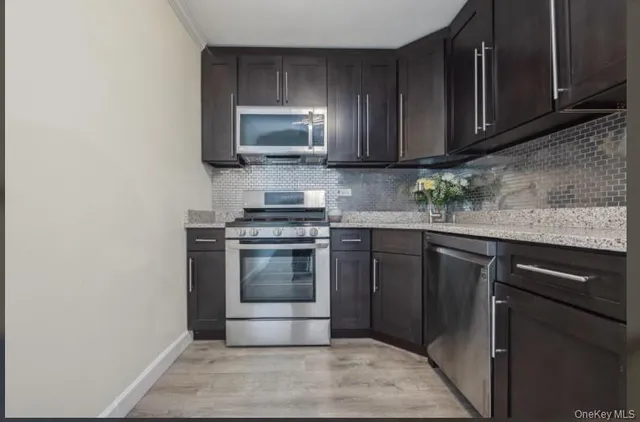 a kitchen with stainless steel appliances granite countertop a stove microwave and sink