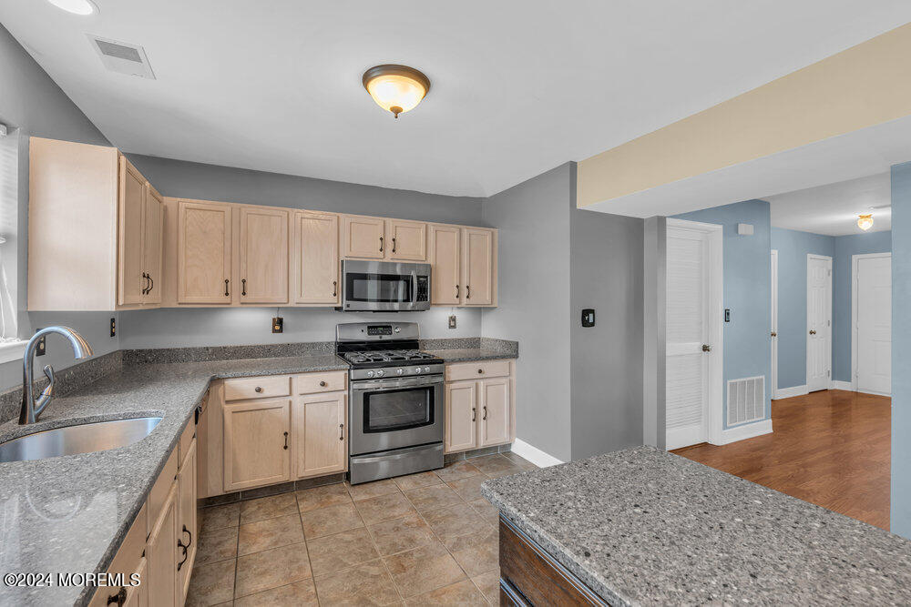 7 Andrew Street Howell, NJ 07731 - Photo 24 of 57 a kitchen with stainless steel appliances granite countertop a sink dishwasher stove and refrigerator