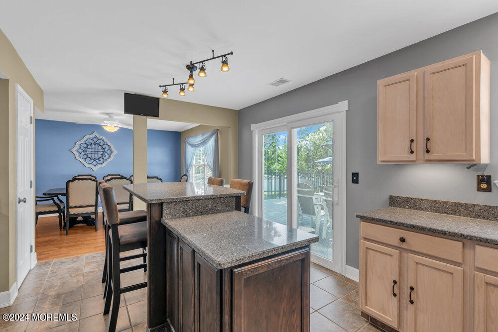 7 Andrew Street Howell, NJ 07731 - Photo 25 of 57 a open kitchen with stainless steel appliances granite countertop a stove top oven a sink with dining table and chairs
