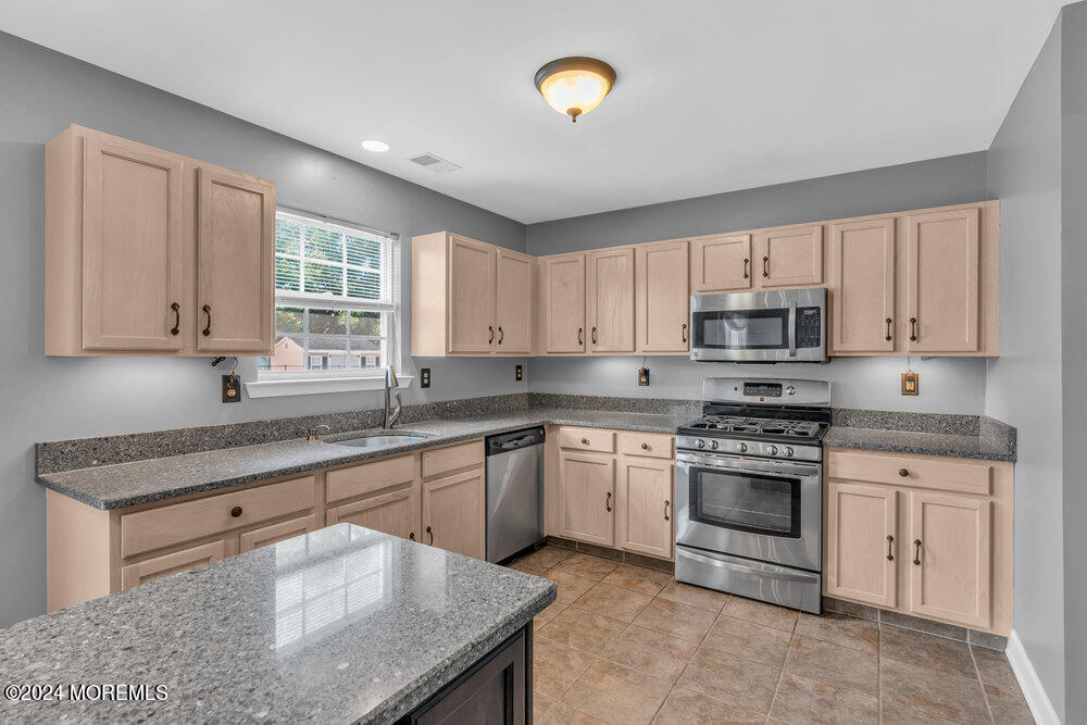7 Andrew Street Howell, NJ 07731 - Photo 26 of 57 a kitchen with stainless steel appliances granite countertop a stove a sink dishwasher and a microwave oven with white cabinets