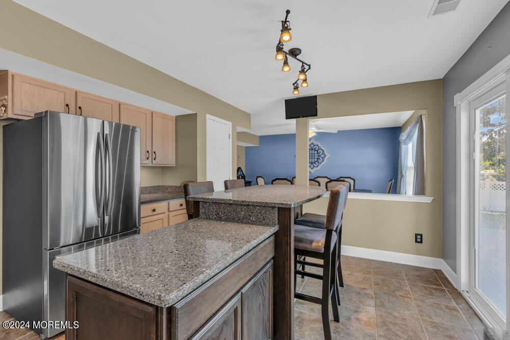 7 Andrew Street Howell, NJ 07731 - Photo 28 of 57 a kitchen with stainless steel appliances granite countertop a table chairs and microwave