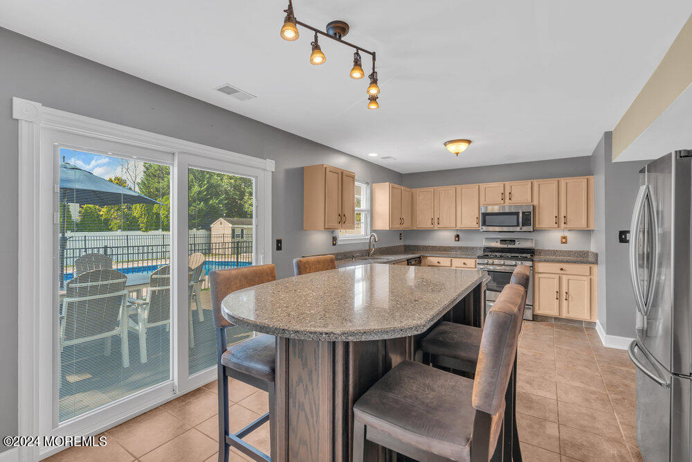 7 Andrew Street Howell, NJ 07731 - Photo 3 of 57 a dining room with stainless steel appliances granite countertop a table chairs and a sink