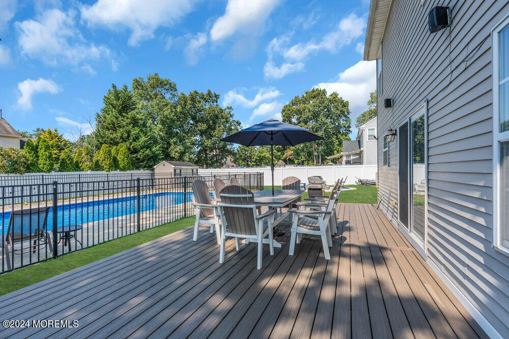7 Andrew Street Howell, NJ 07731 - Photo 44 of 57 a view of a roof deck with table and chairs with wooden floor and fence