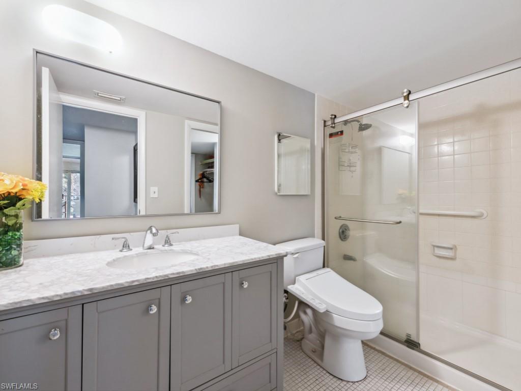 3 Bluebill Avenue, Unit 206 Naples, FL 34108 - Photo 10 of 19 a bathroom with a granite countertop sink toilet and shower