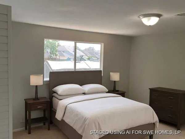 a bedroom with a bed and a lamp on dresser