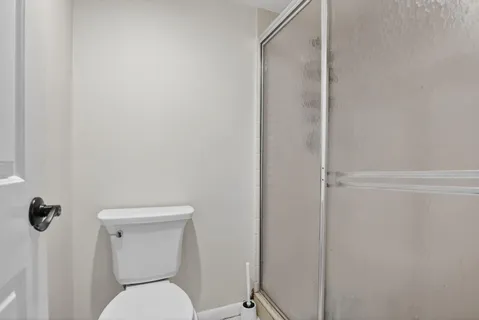 a white toilet sitting next to a shower