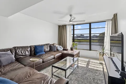 a living room with furniture and a floor to ceiling window