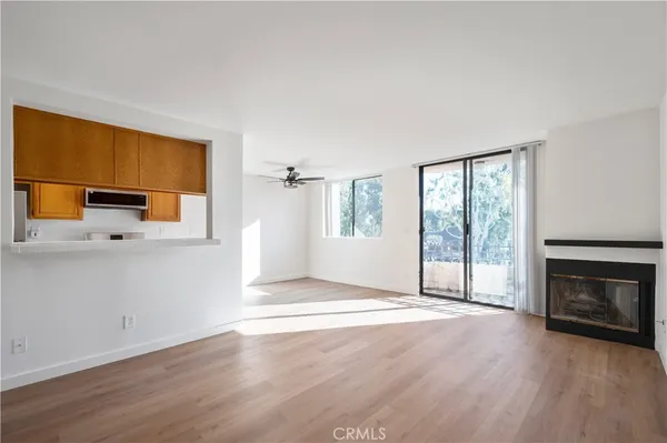 a view of a livingroom with wooden floor and a ceiling fan