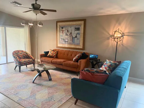 a living room with furniture and a ceiling fan