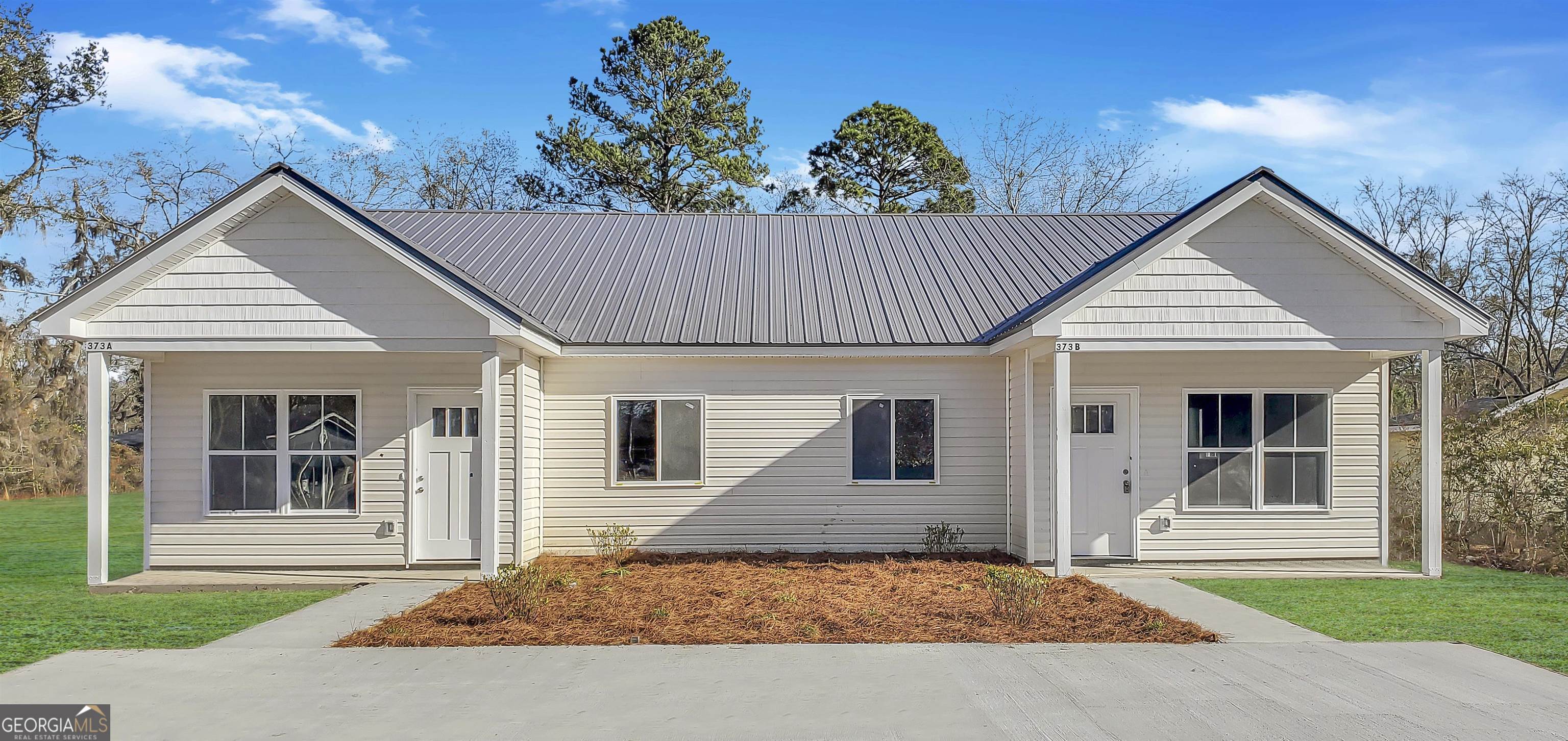 373 Carter Road, Unit A & B Allenhurst, GA 31301 - Photo 1 of 1 a view of a white house with a small yard and large window