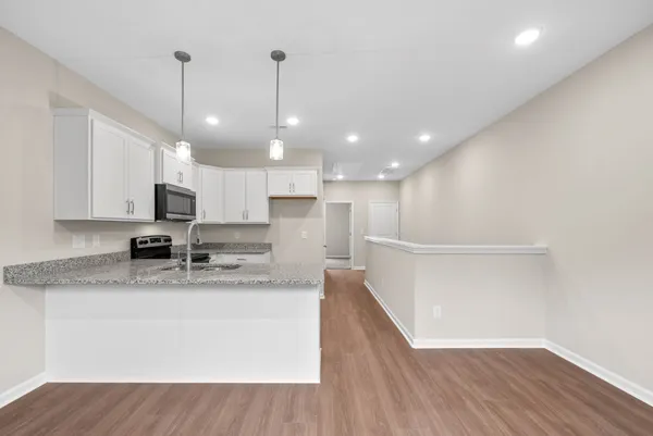 a view of a kitchen with a sink and dishwasher with wooden floor